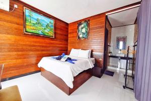 Un dormitorio con una cama en una pared de madera. en The Beach Huts Lembongan, en Nusa Lembongan