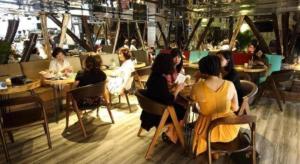 un grupo de personas sentadas en mesas en un restaurante en GreenTree Saigon Dong Du Hotel, en Ho Chi Minh