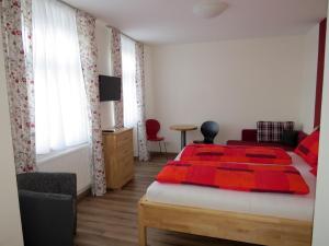 ein Schlafzimmer mit einem Bett mit einer roten Decke darauf in der Unterkunft Gasthof Christine Enne in Albrechtsberg an der Grossen Krems + 16 Fotos