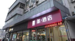 Pai Hotel Xuzhou Railway Station في سوزهو: يوجد متجر به علامة حمراء على جانب المبنى