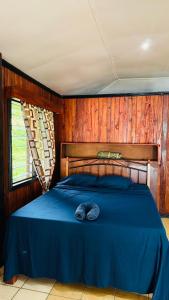 White Sandy Beach Dive Resort في Naviti Island: غرفة نوم بسرير ازرق وعليه قبعة