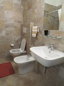 a bathroom with a white sink and a toilet at Hotel Fortuna in San Bartolomeo al Mare