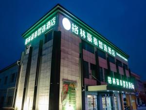 GreenTree Inn Express Shandong Qingdao Chengyang District Aodong Road في تشينغداو: عماره عليها ساعه