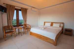 a bedroom with a bed and a table and chairs at Pande Homestay in Canggu