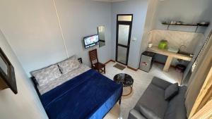 a living room with a blue bed and a couch at COMFORT HAVEN Studio in Ilemera
