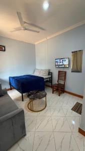 a living room with a blue bed and a couch at COMFORT HAVEN Studio in Ilemera
