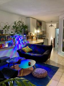 een woonkamer met een bank en tafels en een keuken bij Chez Corinne in Valence