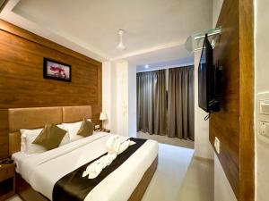 a bedroom with two beds and a flat screen tv at Palm Breeze Hotel - Colaba in Mumbai