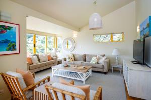 a living room with a couch and a table at Island View - Stay Waiheke in Palm Beach