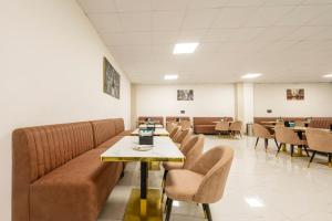 een wachtkamer met een bank en tafels en stoelen bij Treebo Accent Park Hotel And Banquet in Noida