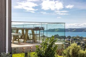 a glass house with a view of the ocean at Overview - Stay Waiheke in Ostend