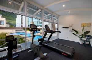 a gym with two treadmills and a swimming pool at Beaumont Apartments in Mount Maunganui