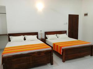 two beds sitting next to each other in a room at Didula Holiday Resort Anuradhapura in Anuradhapura