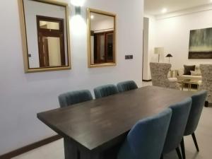 comedor con mesa de madera y sillas azules en Villa NU 380, en Galle
