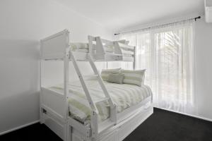 En eller flere senge i et værelse på Ohana Hale, Safety Beach