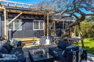 a patio with two couches and a table at Welcome Cottage - Stay Waiheke in Oneroa