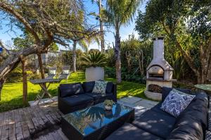 a living room with a couch and a fire pit at Welcome Cottage - Stay Waiheke in Oneroa +27 photos