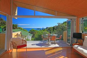Una sala de estar con vista al mar. en Barefoot Spirit - Stay Waiheke, en Palm Beach