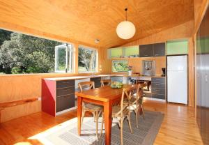 Una cocina con una mesa y sillas de madera. en Barefoot Spirit - Stay Waiheke, en Palm Beach 31 fotos más