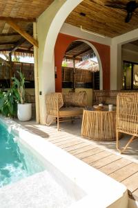 un patio con muebles de mimbre y una piscina en DILAW Villa avec piscine privée, en El Nido