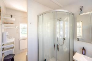 a bathroom with a shower and a sink at Welcome Cottage - Stay Waiheke in Oneroa