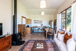 The Vineyard Cottage - Stay Waiheke في Onetangi: غرفة معيشة بها أريكة وطاولة