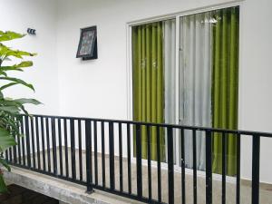 a balcony with green curtains and a window at Didula Holiday Resort Anuradhapura in Anuradhapura