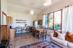 The Vineyard Cottage - Stay Waiheke في Onetangi: غرفة معيشة بها أريكة وطاولة