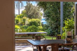 Una puerta abierta a un patio con mesas y sillas. en Paradise on Palm - Stay Waiheke, en Palm Beach 29 fotos más