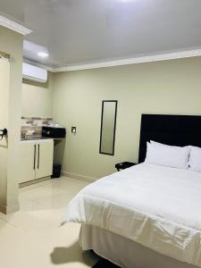 a bedroom with a large white bed and a mirror at PholaBnB in Pongola