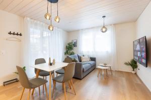 a living room with a couch and a table and chairs at Mountain view with balcony and free parking in Lungern