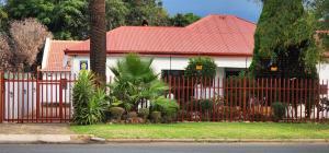 a red fence in front of a house at Khayelihle Guest house in Benoni