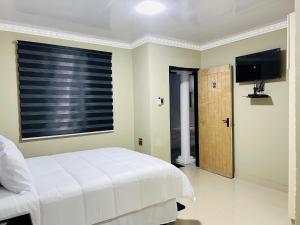 a bedroom with a white bed and a window at PholaBnB in Pongola