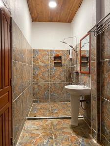 Un baño con lavabo y pared de piedra. en Letana Guesthouse, en Ban O