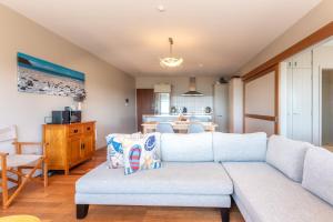 uma sala de estar com um sofá e uma cozinha em The Sands - Apartment 15 - Stay Waiheke em Onetangi mais 17 fotografias