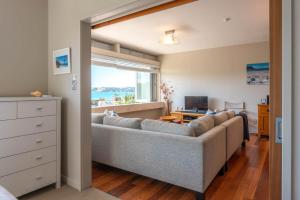 a living room with a couch and a window at Horizon on The Beach at The Sands in Onetangi +17 photos