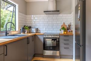 a kitchen with a sink and a stove at Treetop Escape - Stay Waiheke in Waiheke Island