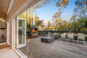 a patio with a couch and a fireplace at Skyview Onetangi - Stay Waiheke in Waiheke Island