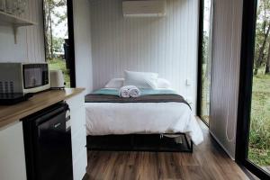 ArrawarraにあるSolitary Islands Farm 3 by Tiny Awayのベッドとタオル2枚のある寝室