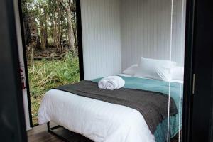 ArrawarraにあるSolitary Islands Farm 3 by Tiny Awayのベッドとタオル2枚のある寝室