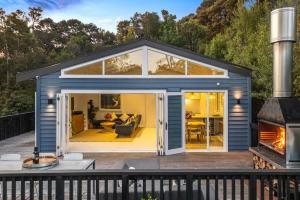 a tiny house with a living room and a fireplace at Skyview Onetangi - Stay Waiheke in Waiheke Island