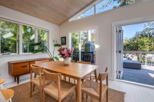a dining room with a wooden table and chairs at Skyview Onetangi - Stay Waiheke in Waiheke Island +16 photos