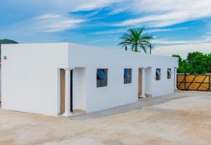 a white building with a palm tree in the background at PholaBnB in Pongola
