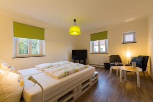a bedroom with a bed and a table and a tv at Kellermanns-Apartment in Memmingen