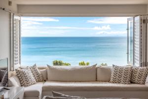 a living room with a couch in front of a large window at The Sands Apartment 8 - Stay Waiheke in Waiheke Island