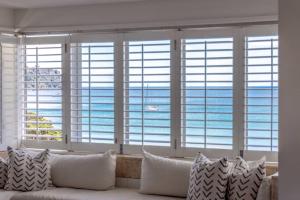 a living room with a couch in front of a window at The Sands Apartment 8 - Stay Waiheke in Waiheke Island
