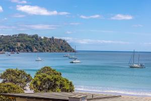 a view of a beach with boats in the water at The Sands Apartment 8 - Stay Waiheke in Waiheke Island