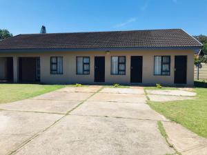 a house with a large driveway in front of it at Mhlezi Lodge in Richards Bay +2 photos