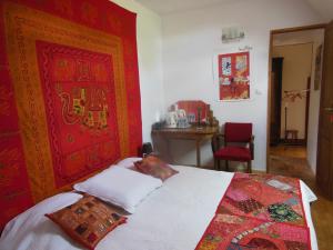 een slaapkamer met een bed en een rode muur bij Chambres d'Hôtes des Grands Prés in Argentan