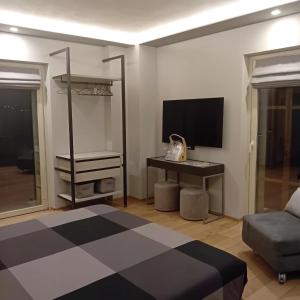 a living room with a tv and a desk with a computer at CasettaLuce in Cuneo